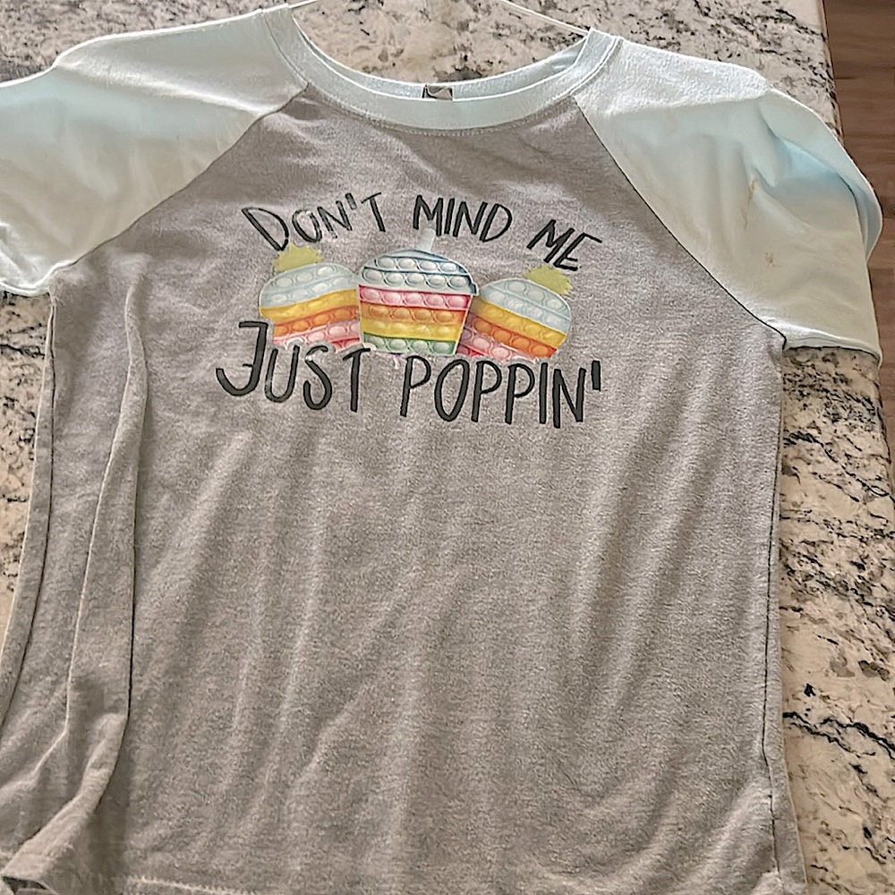 It is a medium size shirt,light blue sleeves,and pop it’s on the front